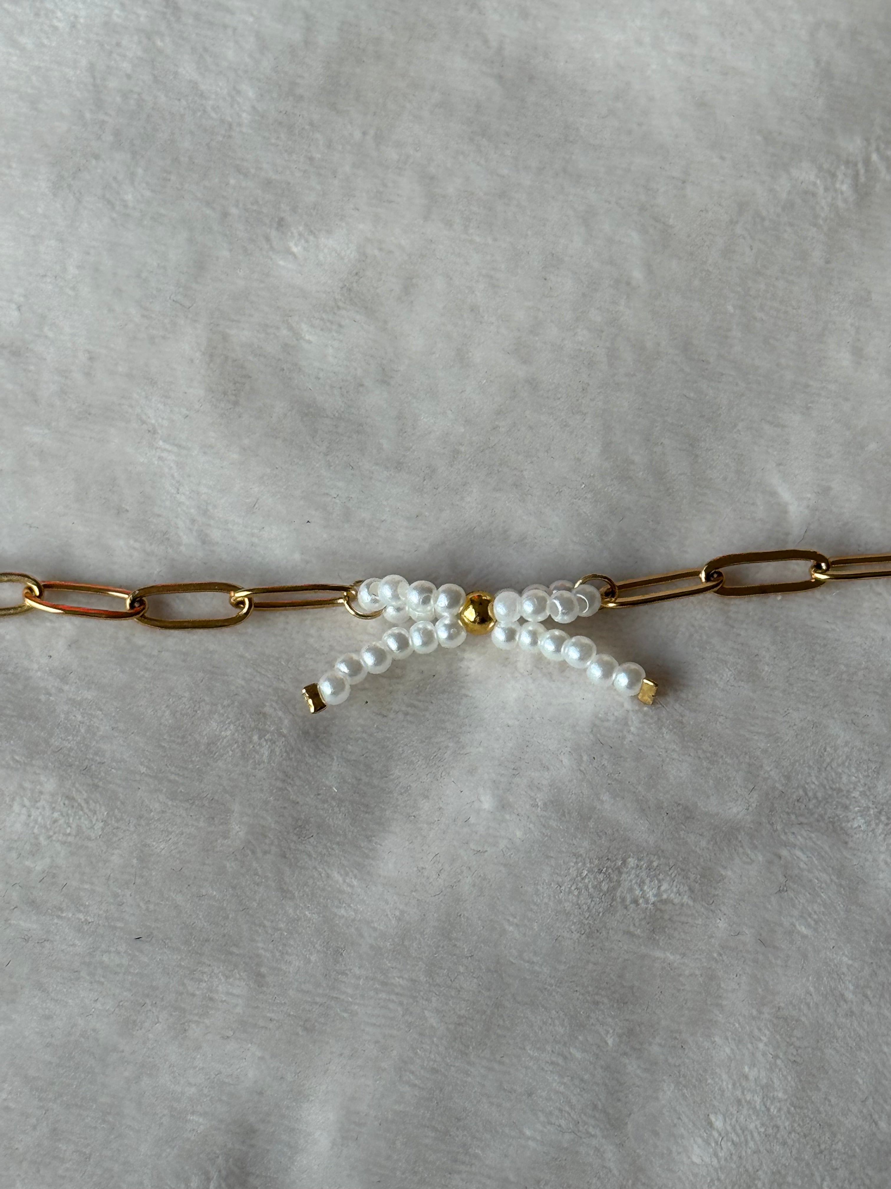 Armband goud/wit strikje