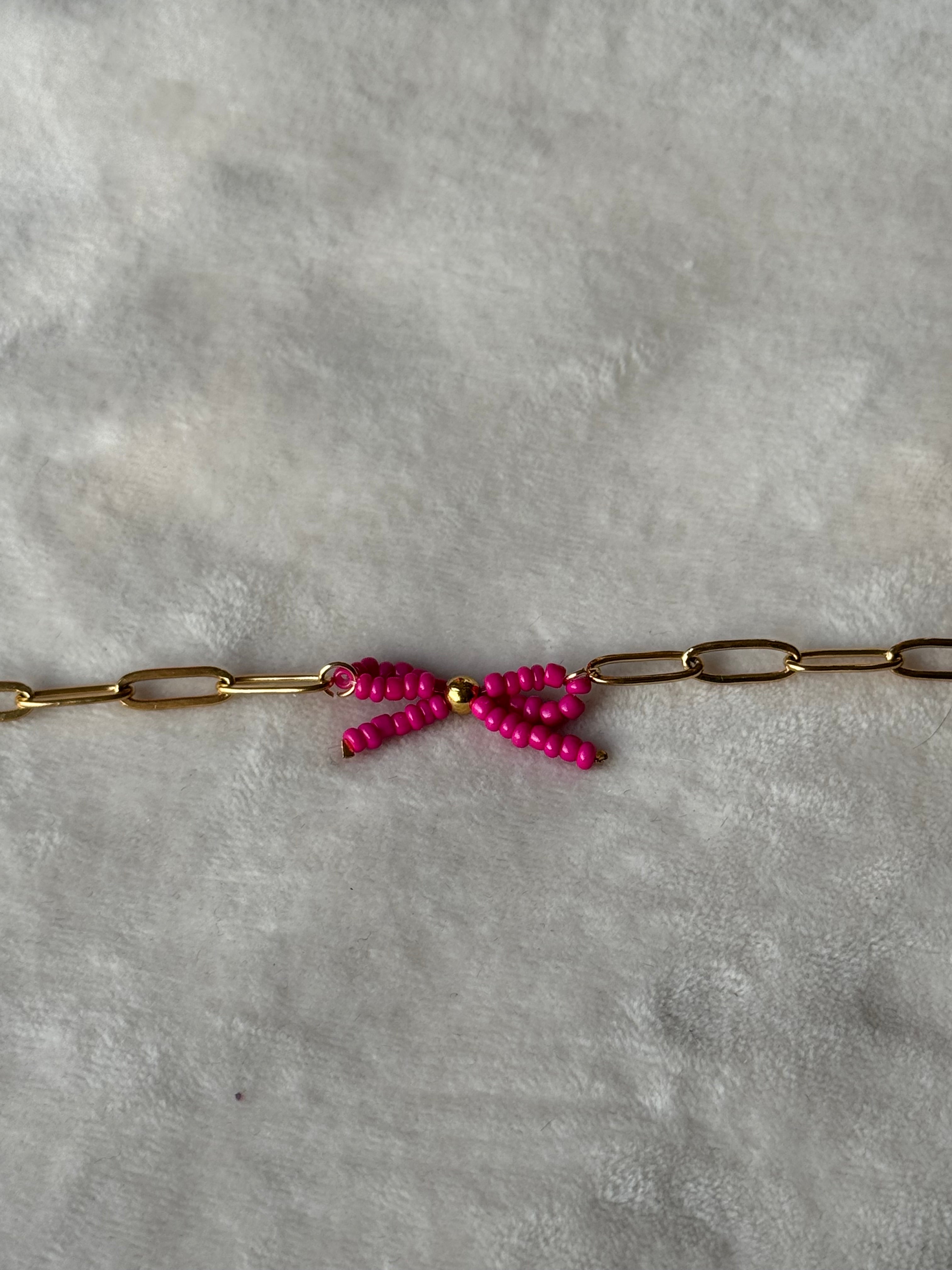 Armband goud/roze strikje